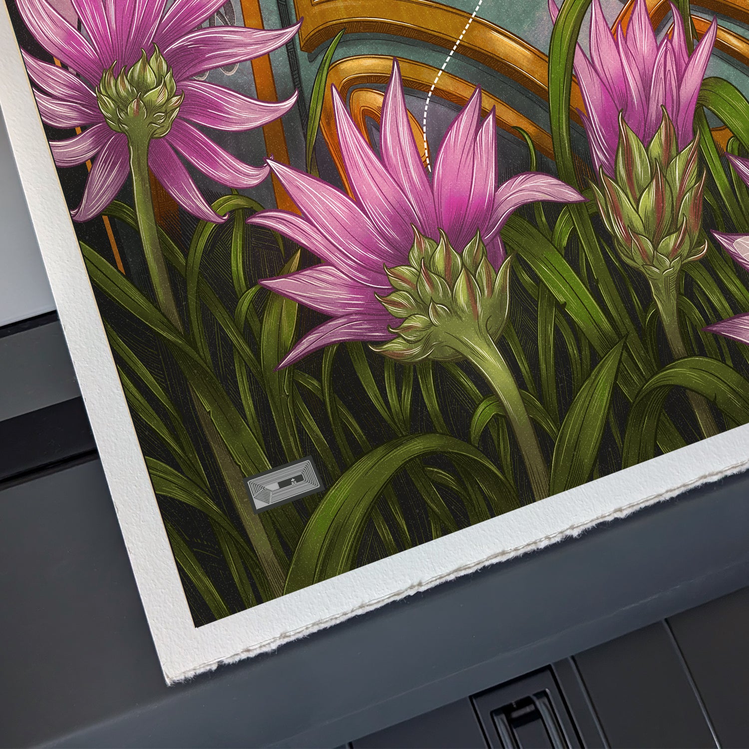 Close-up of a print with pink flowers and green leaves on a dark surface.